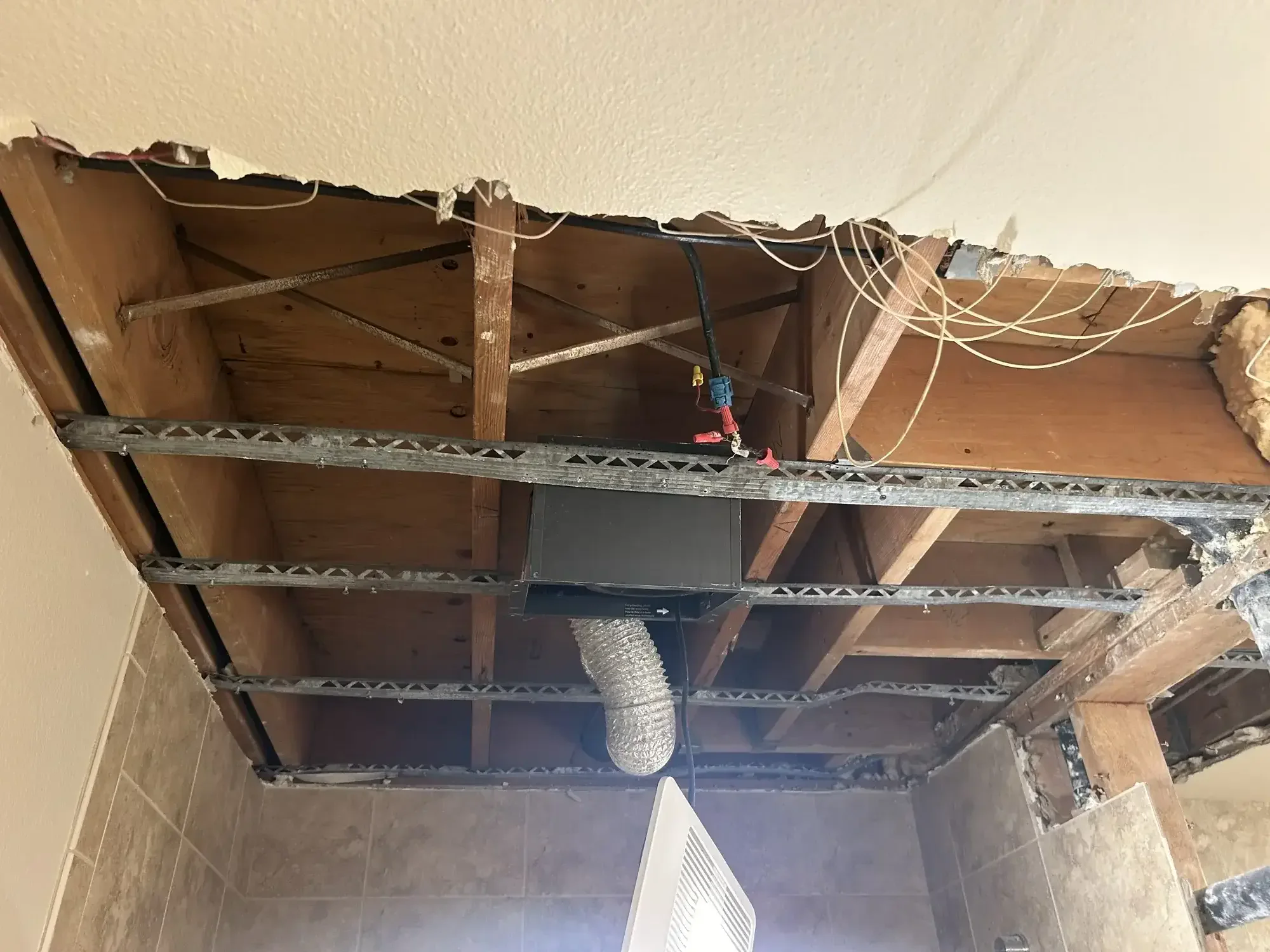 Bathroom mid demolition with original framing and rough in exposed